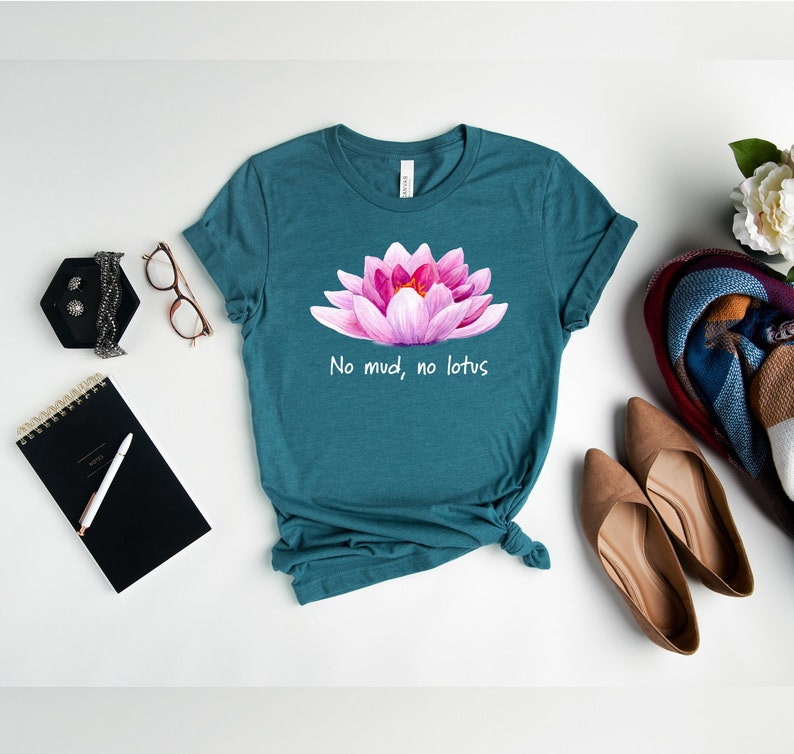 May include: Teal blue t-shirt with a pink lotus flower graphic and the text "No mud, no lotus".