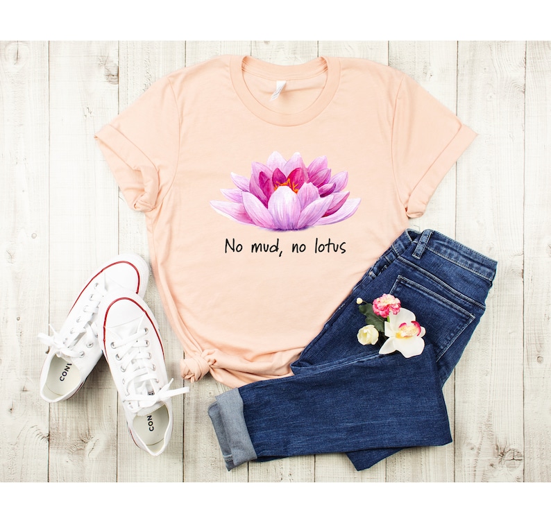 May include: A peach-colored t-shirt with a pink lotus flower graphic and the text "No mud, no lotus".