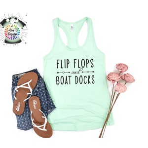May include: A light green tank top with the text "FLIP FLOPS and BOAT DOCKS" in black. The text is surrounded by two arrows with hearts at the ends.