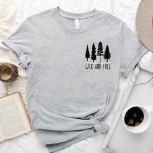 May include: Gray t-shirt with a black graphic of four trees and the text "Wild and Free".