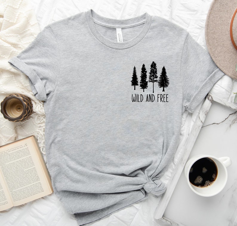 May include: Gray t-shirt with a black graphic of four trees and the text "Wild and Free".
