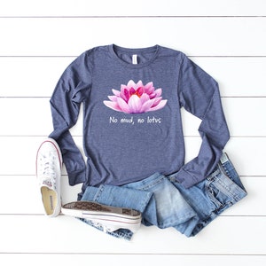 May include: A navy blue long-sleeved t-shirt with a pink lotus flower graphic and the text "No mud, no lotus".