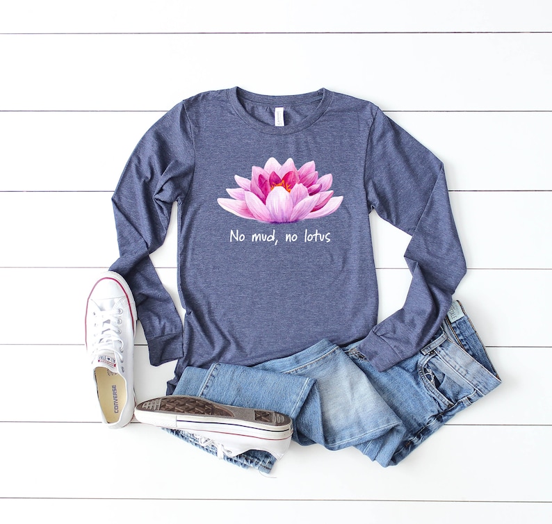 May include: A navy blue long-sleeved t-shirt with a pink lotus flower graphic and the text "No mud, no lotus".