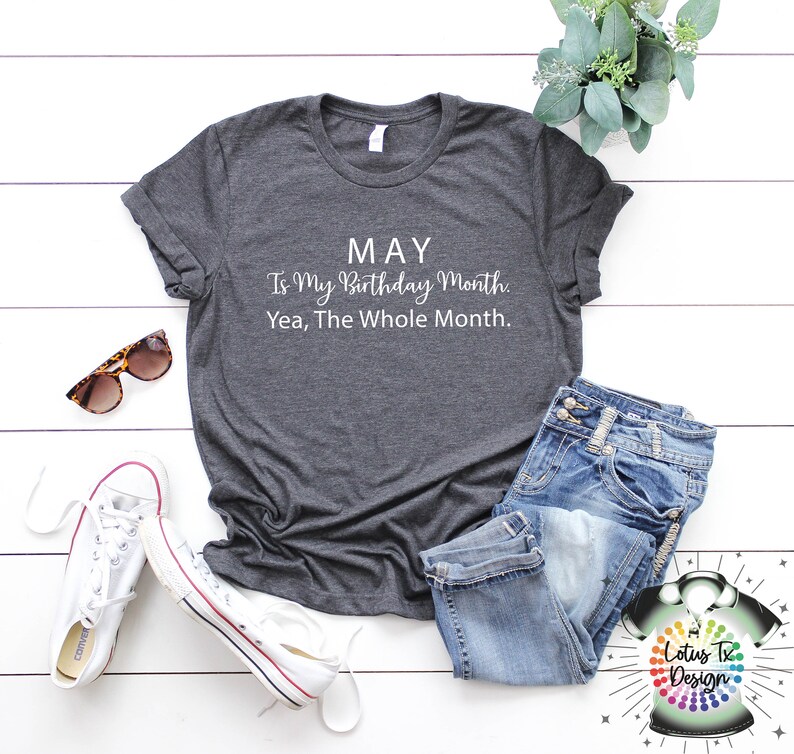 May include: A dark gray t-shirt with white text that reads "MAY Is My Birthday Month. Yea, The Whole Month."