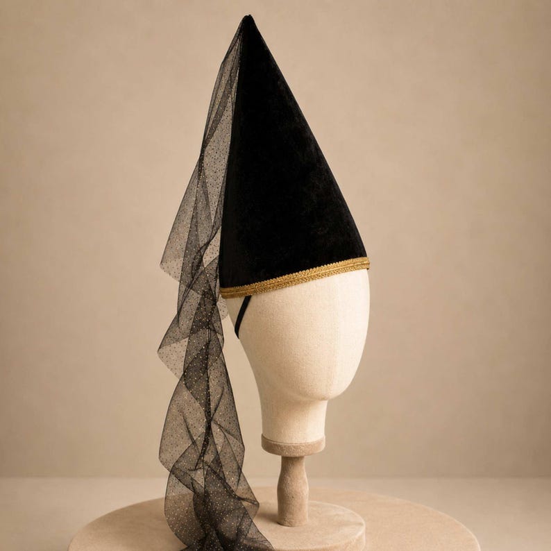 A mannequin head wearing a black hat with a long, flowing veil draped over the side.