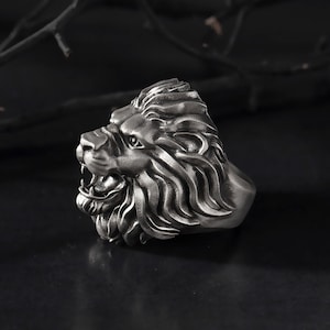 Puede incluir: Un anillo de cabeza de le&oacute;n de plata con un dise&ntilde;o detallado. El anillo est&aacute; hecho de metal y tiene un dise&ntilde;o realista de cabeza de le&oacute;n.