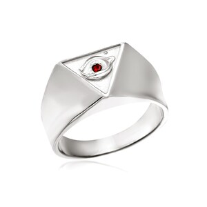 Puede incluir: Un anillo de plata con un dise&ntilde;o triangular que presenta un ojo con una piedra preciosa roja en el centro.