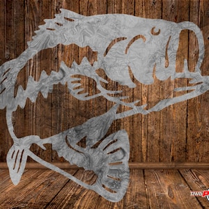 May include: A metal cutout of a bass fish, with a textured, wood-like finish. The fish is facing right and has its mouth open. The cutout is on a wooden background.