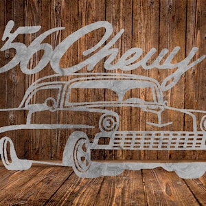 May include: A metal cutout of a classic 1955 Chevy car, with the text "55 Chevy" above the car. The artwork is in a light gray color and is set against a wooden background.