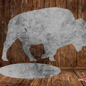 May include: A silver silhouette of a buffalo standing over a circular hole in a wooden floor. The buffalo is made of a textured metal and has a detailed design.
