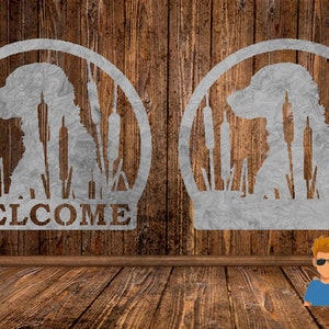 Può includere: Due sagome metalliche di un cane in un campo di tife, una con la parola "WELCOME" sotto. Le sagome sono su uno sfondo di legno.
