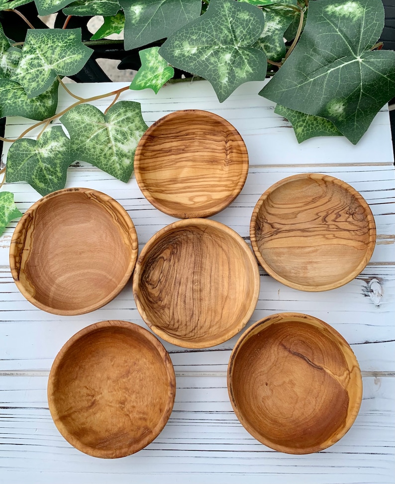 K&ouml;nnte beinhalten: Sechs kleine, runde Holzschalen aus Olivenholz. Die Schalen sind alle unterschiedlich gro&szlig; und haben eine nat&uuml;rliche Holzoptik.