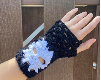 May include: Black and white crocheted wrist warmer with a skull design.