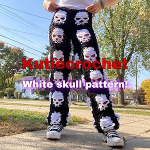 Puede incluir: Una persona lleva pantalones de crochet blanco y negro con un patrón de calavera. Los pantalones se llaman "Kutiecrochet White Skull Pattern!"