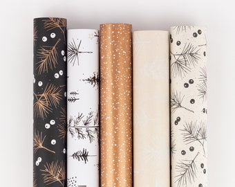 Può includere: Cinque rotoli di carta da regalo decorativa con vari motivi. I disegni includono rami di pino dorati su nero, alberi bianchi, oro con punti bianchi, crema con alberi bianchi e rami di pino neri con bacche.