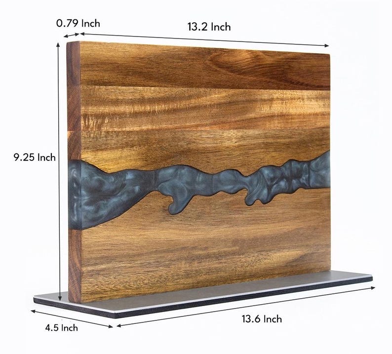 K&ouml;nnte beinhalten: Holzschneidebrett mit einem Flussdesign aus dunkelblauem Harz. Das Brett ist 33,5 cm lang, 23,5 cm hoch und 2 cm dick. Es steht auf einem Metallsockel, der 34,5 cm lang und 11,4 cm breit ist. Das Holz hat eine nat&uuml;rliche Maserung.