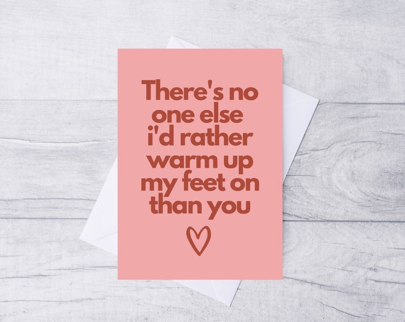 May include: A pink card with the text "There's no one else I'd rather warm up my feet on than you" in brown text with a small heart at the bottom.