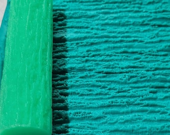 May include: A bright green textured roller for applying paint or other materials. The roller is made of a soft, flexible material and has a slightly rounded shape.