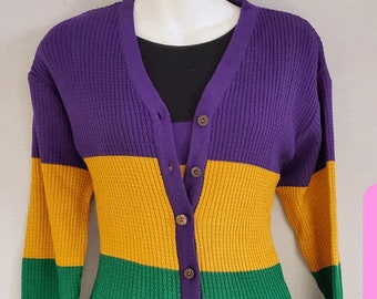 Pode incluir: Um cardigan listrado roxo, dourado e verde com fecho de botões.
