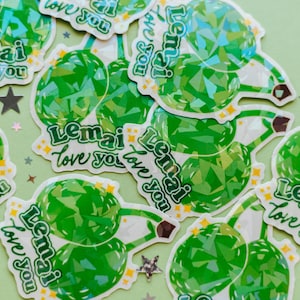 May include: A collection of green and white stickers with the text "Lemai Love you" repeated on each sticker. The stickers have a holographic finish and feature a green and white geometric pattern.