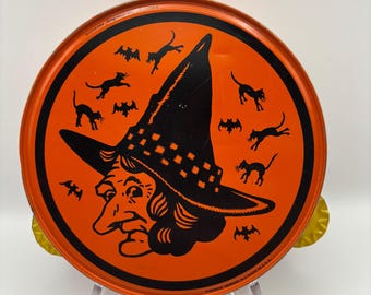 May include: Round orange Halloween tray with a black witch's hat, witch face, black cats, and bats. The tray has gold-colored scalloped edges and is made in the USA.