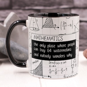 May include: White ceramic mug with a black handle and rim, decorated with mathematical diagrams and the quote: "MATHEMATICS the only place where people can buy 64 watermelons and nobody wonders why."