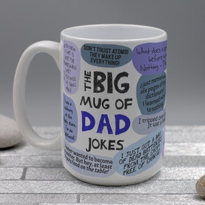 May include: White ceramic mug with the text "The Big Mug of Dad Jokes" in black and blue. The mug is covered in speech bubbles with various jokes. The mug has a large handle.