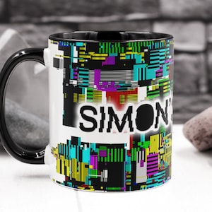 May include: Black and white mug with a colourful glitch pattern and the name "SIMON" in black text.