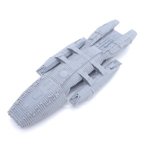 以下が含まれることがあります： 細長く尖った鼻を持つ、グレーの3Dプリントされた宇宙船のモデル。モデルは、テクスチャ加工された表面で詳細に作られています。