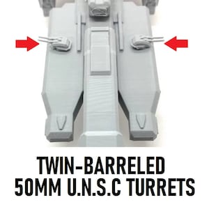 Op de afbeelding: Een close-up van een grijs, 3D-geprint model van een ruimteschip met dubbele 50 mm U.N.S.C.-torentjes aan elke kant. De torentjes zijn naar voren gericht en hebben een grijs, getextureerd oppervlak.