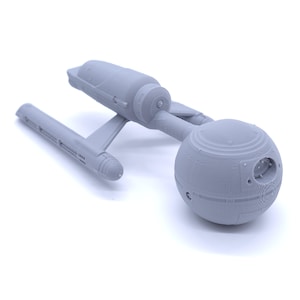 Peut inclure: Maquette gris clair d'un vaisseau spatial, avec une coque principale en forme de soucoupe, une coque secondaire cylindrique et deux nacelles de distorsion. Réplique détaillée d'un vaisseau spatial de fiction.