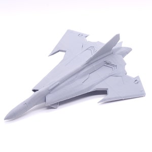 May include: A gray 3D printed model of a futuristic fighter jet with a long, pointed nose and swept wings.