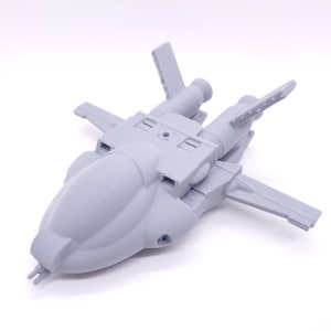 May include: A gray 3D printed model of a spaceship with a rounded body and two engines. The spaceship has two wings and a pointed nose.