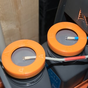 Peut inclure: Deux kits de test d'eau orange et gris avec des tubes blancs et des connecteurs rouges et bleus. Les kits sont étiquetés avec les lettres "A" et "B".