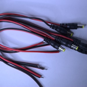 May include: A bundle of black and red electrical wires with multiple black connector plugs with yellow tips.