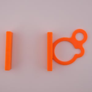May include: Bright orange plastic cable organizers. One is a solid rectangle, and the other has a loop and a clasp. These are designed to keep cables tidy and organized. The items are set against a plain white background.