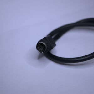 May include: A black cable with a 9-pin connector. The connector has gold-colored pins.