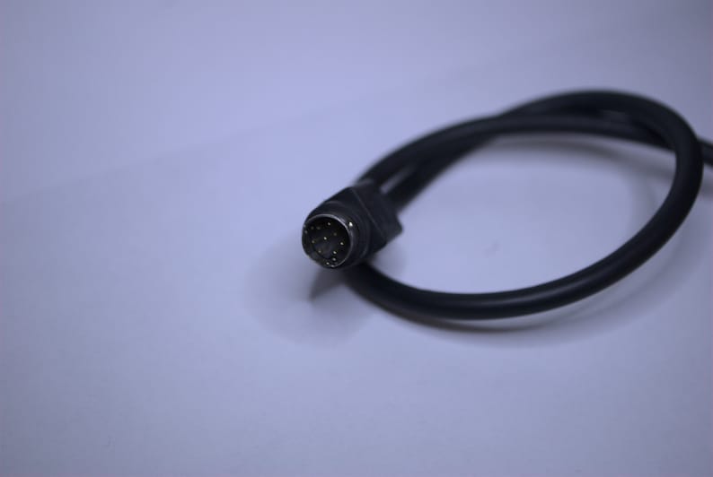 May include: A black cable with a 9-pin connector. The connector has gold-colored pins.