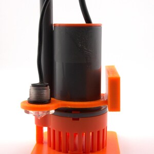 May include: An orange and black submersible pump with a black power cord. The pump has a cylindrical body with an orange base and a series of vertical slots. The top of the pump is black with an orange rim.