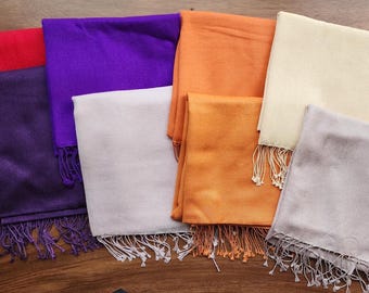 May include: A set of ten scarves in various colors, including red, purple, orange, white, and beige. The scarves are made of a soft, lightweight fabric and have fringed edges.