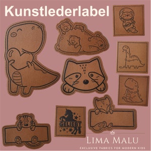 Può includere: Un set di toppe in pelle marrone con vari disegni di animali e testo. Le toppe presentano un dinosauro, un procione, una famiglia di orsi, un unicorno, una tigre e una volpe. Il testo su una toppa dice "Geliebt".