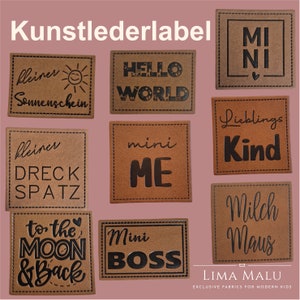 Könnte beinhalten: Neun braune Leder-Etiketten mit schwarzem Text. Die Etiketten zeigen verschiedene Sätze, darunter "Hello World", "Mini Me", "To the Moon & Back", "Mini Boss", "Lieblings Kind", "Kleiner Dreck Spatz", "Kleiner Sonnenschein", "Milch Maus" und "Mi Ni".
