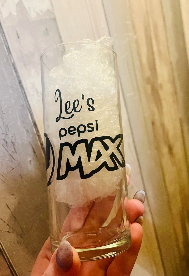 Puede incluir: Un vaso de vidrio transparente con un dise&ntilde;o en blanco y negro que dice "Lee's Pepsi Max".