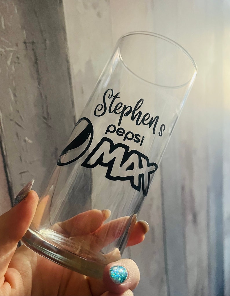 Puede incluir: Un vaso de vidrio transparente con un dise&ntilde;o negro que dice "Stephen's Pepsi Max".