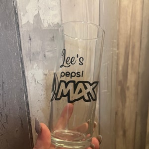 Puede incluir: Un vaso transparente con un dise&ntilde;o negro que dice "Lee's Pepsi Max".
