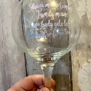 May include: A clear glass with a stem and a quote that reads "Ohana means family. Family means no body gets left behind or forgotten."
