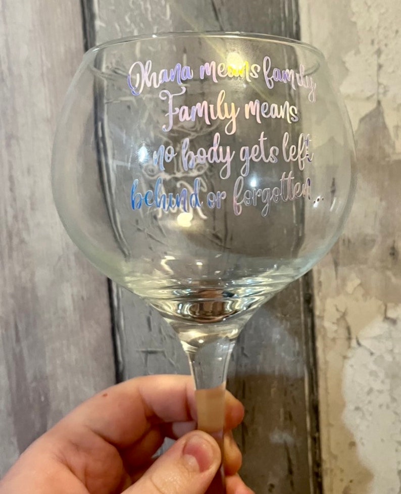 May include: A clear glass with a stem and a quote that reads "Ohana means family. Family means no body gets left behind or forgotten."