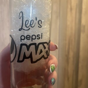 Puede incluir: Un vaso de vidrio transparente con un dise&ntilde;o en blanco y negro que dice "Lee's Pepsi Max".