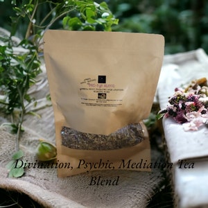May include: A brown paper bag with a clear window, filled with dried herbs. The bag has text that reads "3RD EYE BLEND" and "Divination, Psychic, Meditation Tea Blend". The background includes greenery and a burlap-like surface.