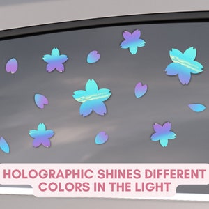 May include: Holographic cherry blossom stickers in various sizes, with a gradient of blue, purple, and green hues. The stickers are applied to a car window. The text on the image reads: "HOLOGRAPHIC SHINES DIFFERENT COLORS IN THE LIGHT."